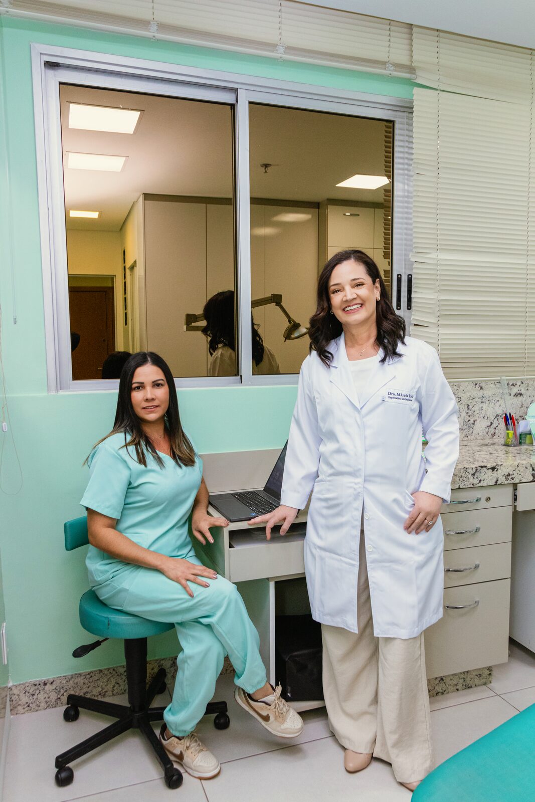 Dra. Márcia Reis com integrante da equipe no consultório